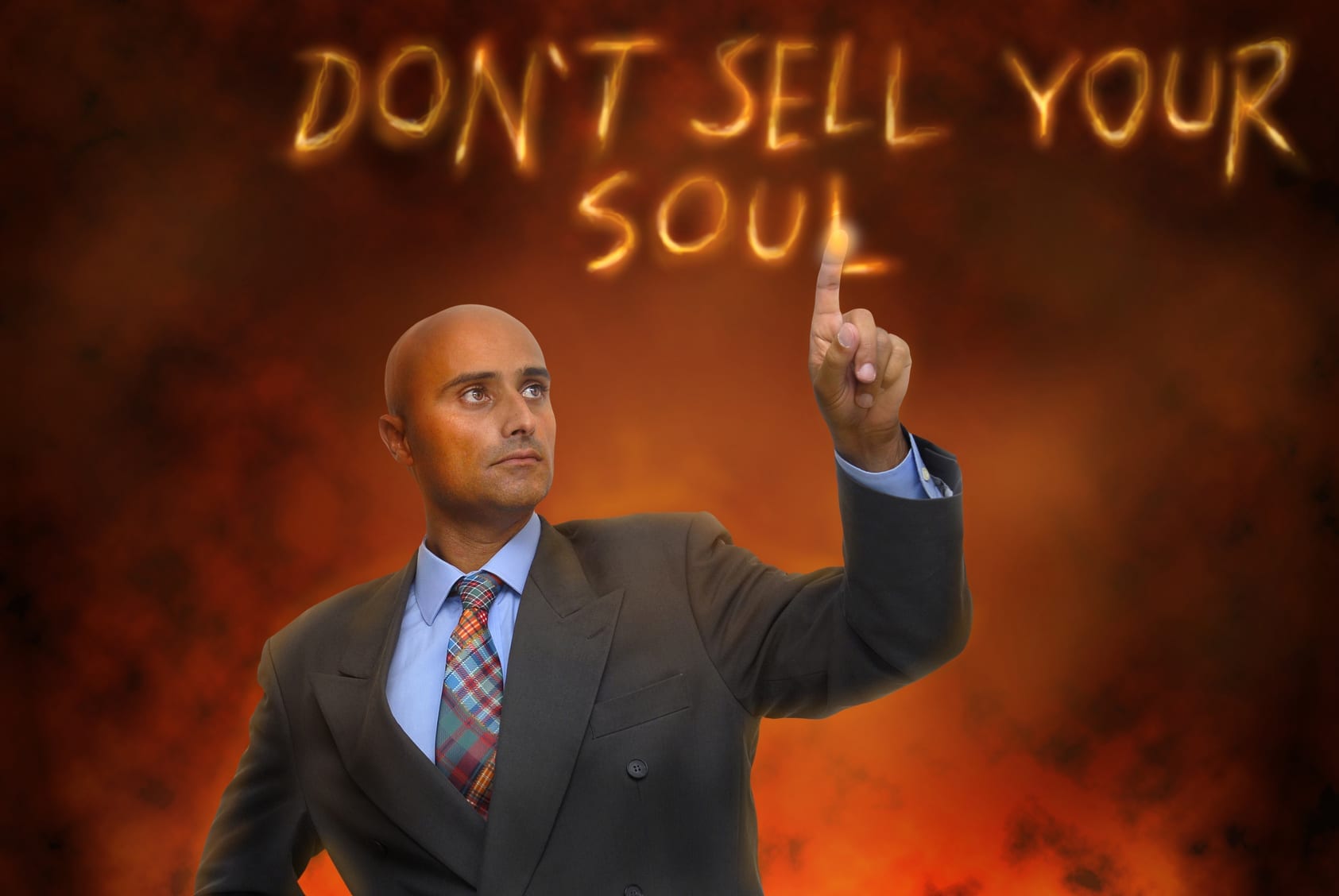Man in hell writing in fiery letters, "Don't sell your soul."